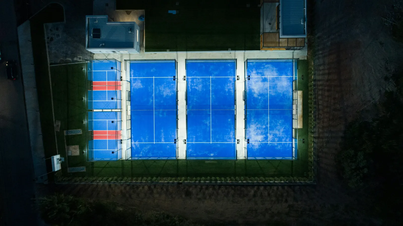 Overhead view of lit padel courts at night