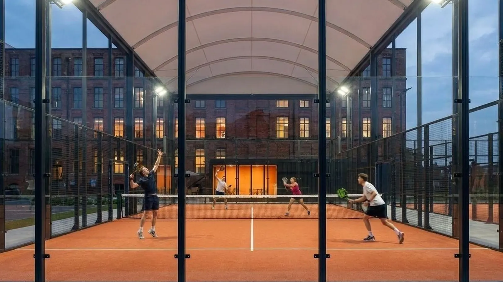 Padel courts under floodlights at dusk