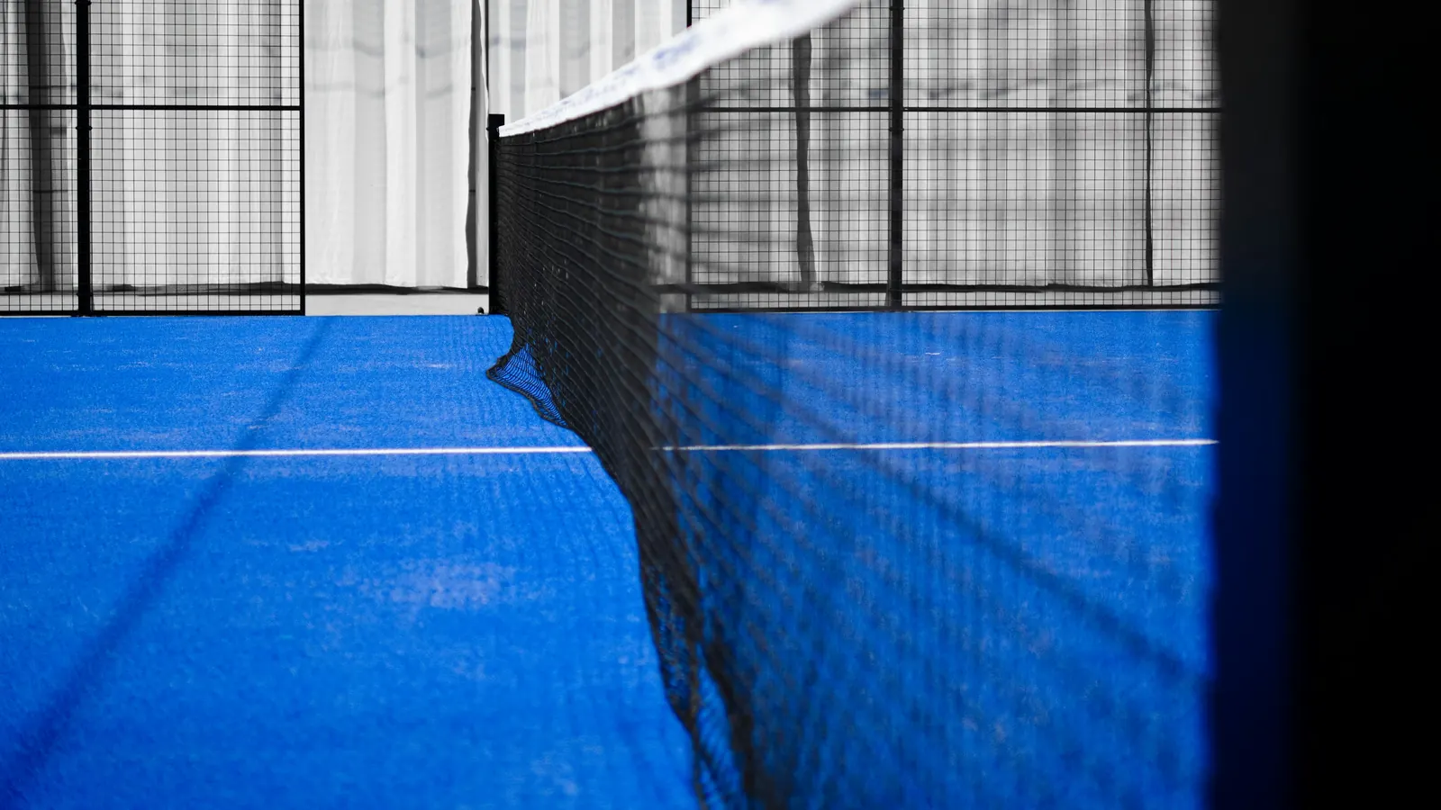 The net across a blue indoor padel court
