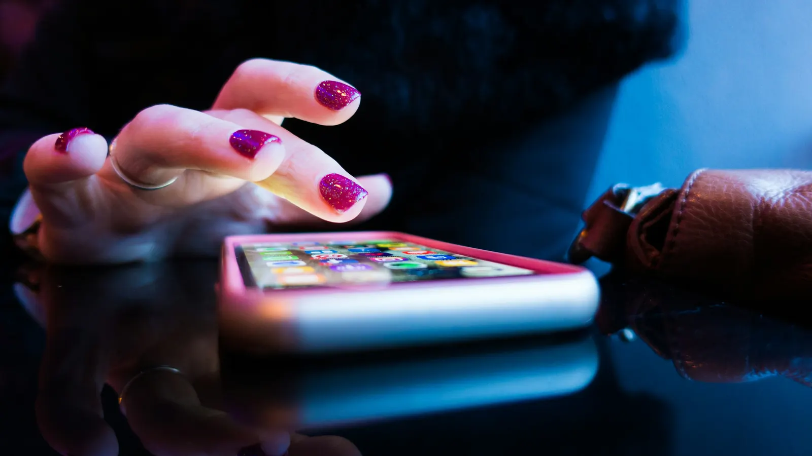 A hand tapping a smartphone on a table