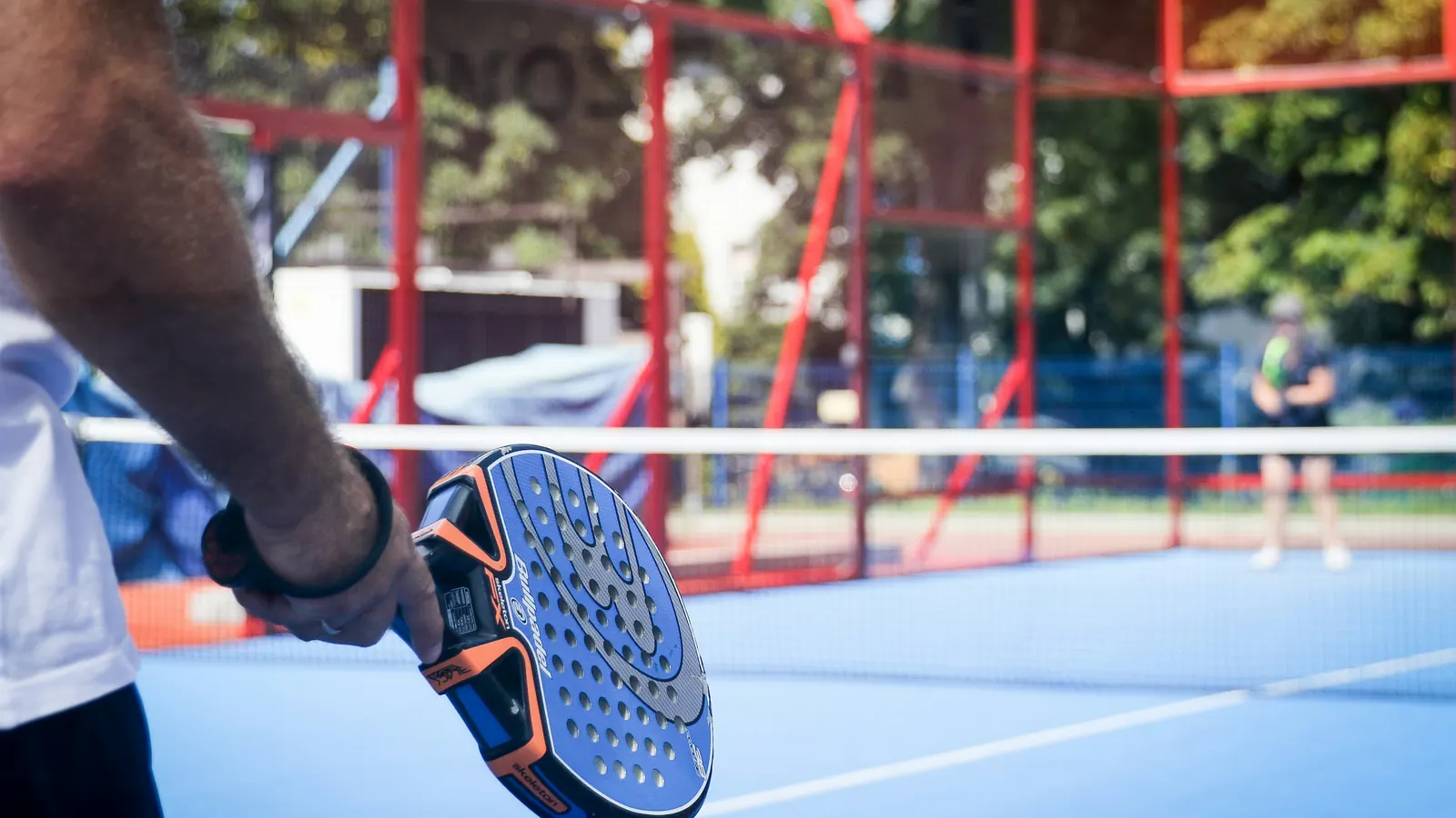 A racket held ready at the net on an outdoor court