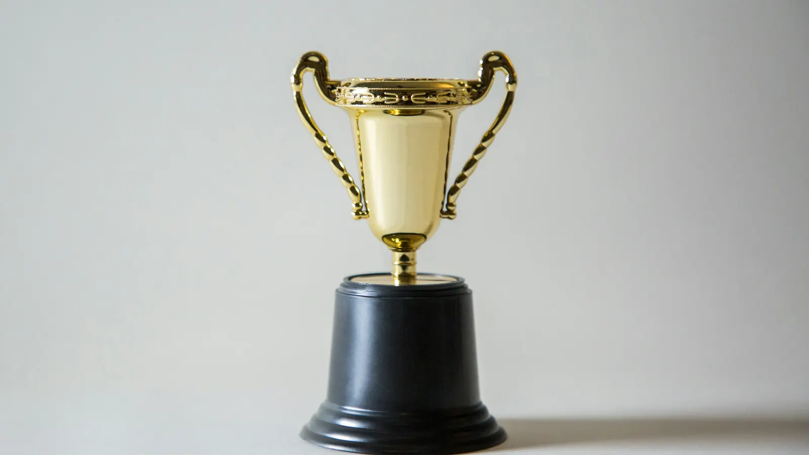 A gold trophy against a plain background